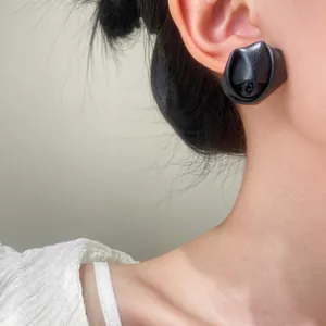 Detailed close-up of a vintage black 3D PU leather rose earring on a model