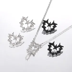 Close-up of punk thorn heart and star earrings with polished metallic finish
