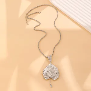 Macro detail of silver leaf pendant with sparkling rhinestones on twisted chain necklace