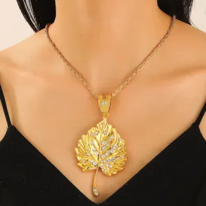 Macro shot of gold leaf pendant with crystal rhinestones on a long rope chain