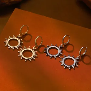 Dettaglio macro di orecchini a pendente a cuore geometrico in oro e argento