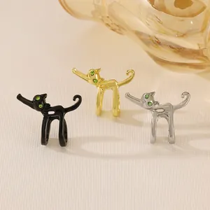 Detailed view of cat ear cuffs in black, gold and silver finishes with green stone eyes