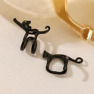 Detail of a cute black cat ear cuff with green rhinestone eyes on a woven texture base