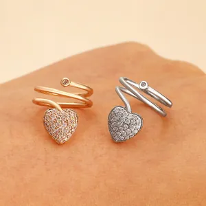 Detail of rose gold and silver spiral rings with heart charms on hands