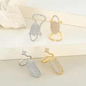 Detailed view of gold and silver nail rings with cubic zirconia on a minimalist stand