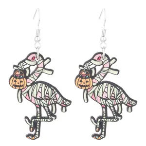 Detail of wooden Halloween earrings featuring mummy flamingos with orange pumpkin lanterns