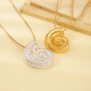 Nahaufnahme von Nautilus-Muschel-Anhängern in Gold und Silber mit Textur