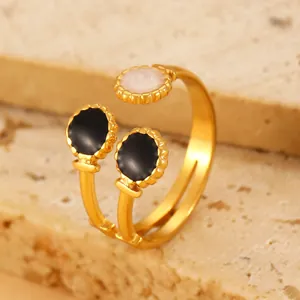 Detail of adjustable gold ring featuring marble-textured and black enamel circular stones