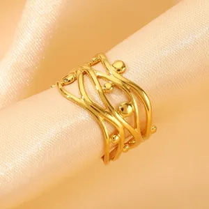 Detailed close-up of a gold-plated multi-layer hollow wave ring with small metal beads