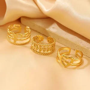 Detailed view of three gold hollow-out adjustable rings on a stone display with satin