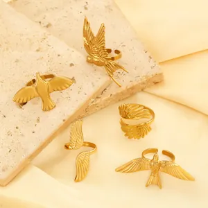 Detail view of five gold adjustable rings featuring flying bird and wing design motifs