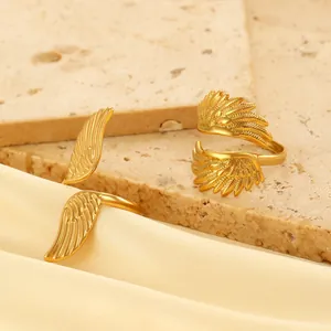 Detailed macro view of two gold adjustable wing rings with intricate feather textures