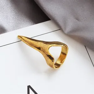 Dettaglio ravvicinato di un anello a artiglio dorato stile punk con finitura opaca