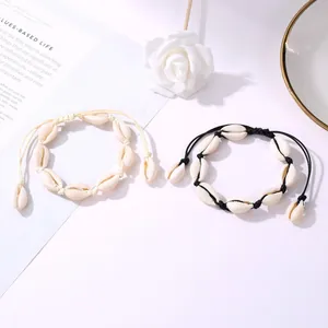 Handmade woven shell bracelets in black and white with adjustable natural cowrie shells