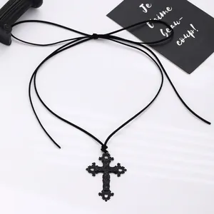 Detailed view of Gothic black cross pendant with adjustable velvet tie on white background