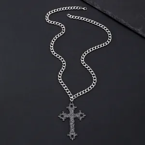 Detail of vintage Gothic cross pendant with intricate relief on a thick Cuban metal chain