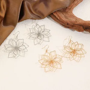 Detailaufnahme mehrlagiger metallisch gewebter Lotusblüten-Ohrringe auf Seidenhintergrund