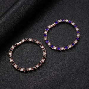 Détails de bracelets en or rose avec cristaux bleus, noirs et clairs sur un fond sombre élégant