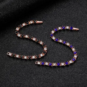 Détail de bracelets tennis en or rose avec pierres de zircon noires et bleues sur noir