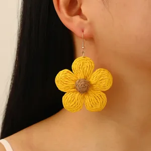 Bohemian style woven raffia sunflower drop earrings in bright yellow with brown center
