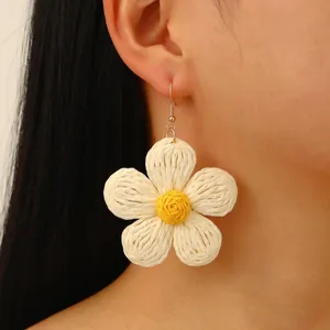 Bohemian style woven raffia sunflower earrings with cream petals and golden ear hooks