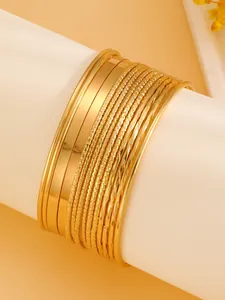 Set of 20 stackable gold alloy bracelets with polished and textured beaded finishes