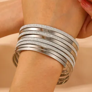 Silver alloy bangle set with polished and frosted finishes shown on a wrist