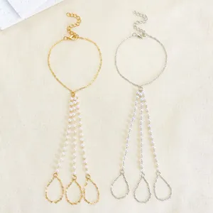 Detail view of gold and silver punk finger bracelets with three rows of white faux pearls