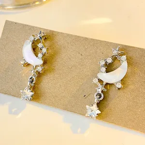 Macro detail of star and crescent moon earrings with rhinestones on a display card