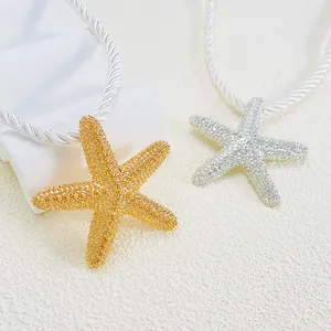 Detailed close-up of starfish pendants in gold sand texture and silver rhinestone finish