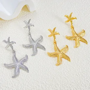 Detail of starfish dangle earrings in gold and silver finish with fine micro-inlay texture