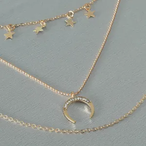 Gold layered necklace with star charms and crescent moon pendant with crystals