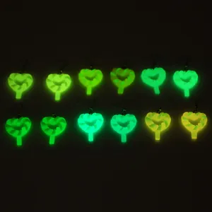 Boucles d'oreilles cœur lumineuses dans le noir avec design torsadé en vert et jaune néon