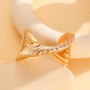 Detailed macro of golden branch leaf bracelet showing polished and frosted metal textures