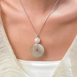 Dettaglio della collana con ciondolo ad anello in giada e perla su cordino