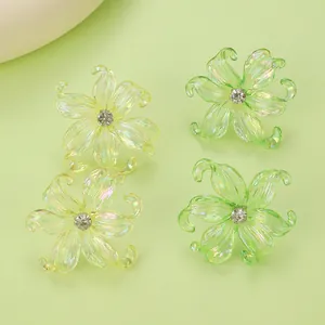 Macro view of colorful resin iris flower earrings with rhinestone centers in yellow and green