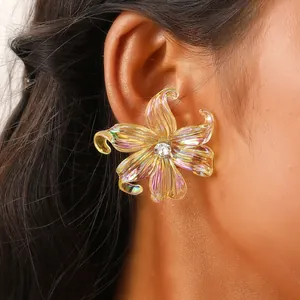 Detail of colorful iridescent y2k iris flower earrings with crystal center on model