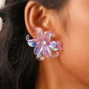 Y2K iris flower earrings in iridescent purple with zircon center on model's ear