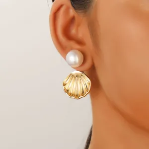 Detail of sea turtle style pearl earrings with shell pendant on female model ear