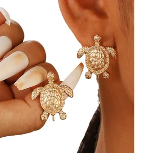 Realistic turtle stud earrings in polished gold metal with detailed shell texture