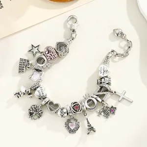 Bracelet à breloques rose multi-éléments avec Tour Eiffel et croix sur fond beige