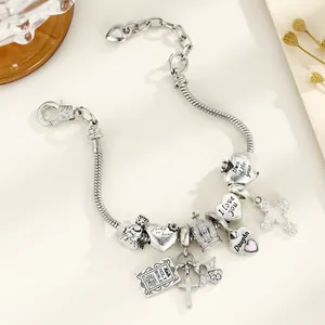 Détail d'un bracelet à breloques avec pendentifs en cœur gravés Mom of the year et I love you