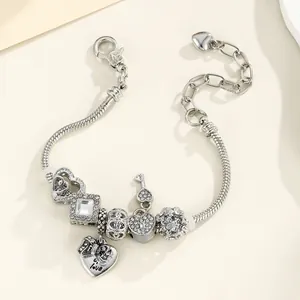 Vue macro détaillée du bracelet serpent argenté avec breloques cœur et pendentif love