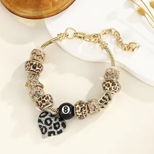 Gros plan d'un bracelet maille serpent doré avec perles léopard et pendentif cœur