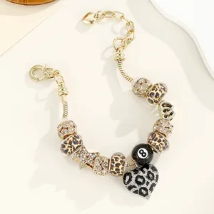 Détail du bracelet chaîne serpent dorée avec perles léopard et pendentif chiffre 8