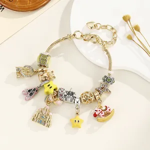 Vue détaillée du bracelet à chaîne serpent dorée avec ballerines roses et breloques