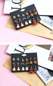 Macro shot of 9 pairs of festive Christmas alloy earrings with reindeer and Santa motifs