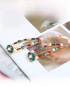 Detailed view of vintage gold-tone hair pins with colorful crystals and white pearls