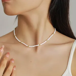Elegante gargantilla de cuentas blancas con detalles dorados usada por una modelo