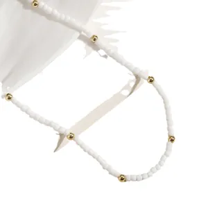 Collar de cuentas minimalista hecho a mano con detalles dorados sobre seda